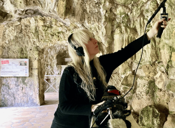 woman recording a cave with a microphone