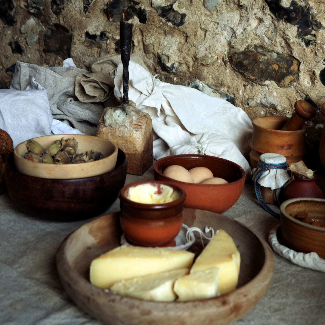 Photo of a selection of Medieval food - cheese, eggs, figs on a table etc.