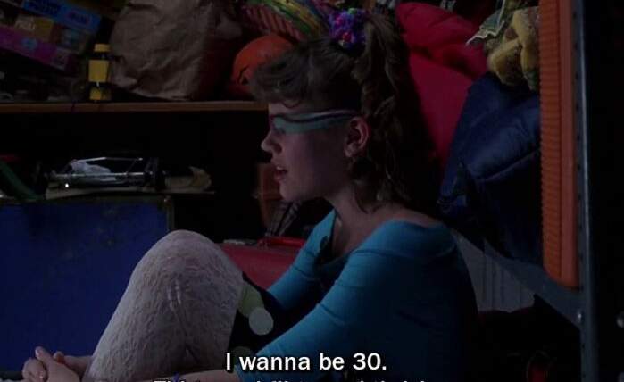 Still of young Jenna Rink sitting down, blindfolded, subtitle is "I wanna be 30. Thirty, flirty and thriving.